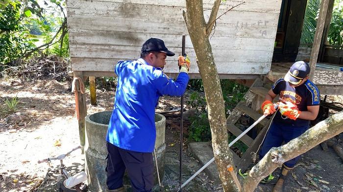 TANGKAP ULAR - Petugas BPBD Aceh Besar menangkap ular jenis King Kobra dengan menggunakan stick di Gampong Weusiteh, Kecamatan Suka Makmur, Aceh Besar, Sabtu (19/7/2025).