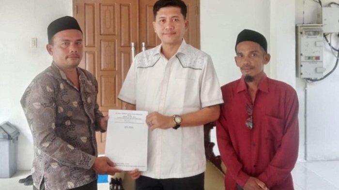 HIBAH TANAH - Bupati Aceh Selatan, Mirwan MS, didampingi Keuchik Harisna Faisal, dan perangkat gampong, memperlihatkan surat hibah tanah yang dibeli secara pribadi untuk kebutuhan perluasan SDN I Lhok Sialang Rayeuk, Pasie Raja, Selasa (29/4/2025).