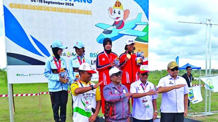 FOTO BERSAMA - Penjabat Bupati Aceh Utara, Dr Mahyuzar MSi didampingi Kepala Disporapar, M Nasir MSi foto bersama usai menyerahkan medali kepada atlet cabor Terbang Layang, di Bandara Sultan Malikussaleh, Rabu (11/9/2024).