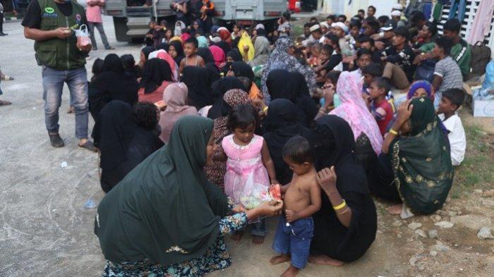 Fitrah membagikan potongan buah semangka kepada anak-anak pengungsi Rohingya, Senin (11/12/2023).