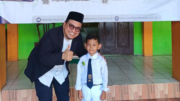 SISWA MIN - Siswa baru MIN 1 Banda Aceh foto bersama Ustadz Wahyu Rezeki pada kegiatan Masa Ta'aruf Siswa Madrasah (MATSAMA) di sekolah itu, Selasa (15/7/2025).