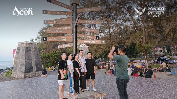 Wisatawan asing berfoto di salah satu ikon di Sabang Fair berupa tiang penunjuk arah yang menunjukkan jarak dari Sabang ke berbagai kota besar dan negara di dunia. Area ini menjadi salah satu spot favorit para pengunjung.