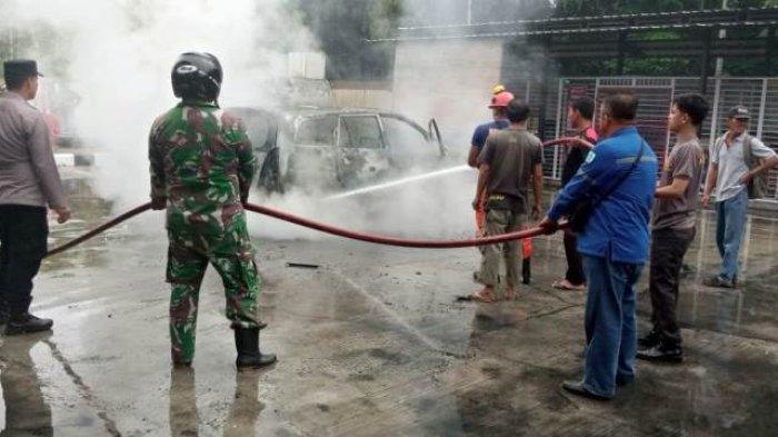 Petugas gabungan memadamkan mobil terbakar di SPBU Suak Puntong, Nagan Raya, Minggu (15/10/2023)