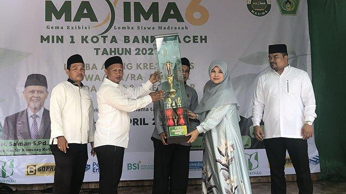 Kepala MIN 1 Banda Aceh, Usman bersama Kasi Penmad Kemenag Banda Aceh, Kusnadi menyerahkan piala juara umum Maxima 6 kepada TK Medina Billingual, Minggu (13/4/2025).