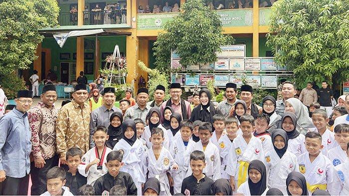 Siswa-siswi kelas minat bakat bela diri MIN 1 Banda Aceh, foto bersama Wali Kota Illiza Sa’aduddin Djamal dan para pejabat Kemenag Provinsi Aceh dan Banda Aceh, usai pembukaan Maxima 6, Sabtu (12/3/2025).
