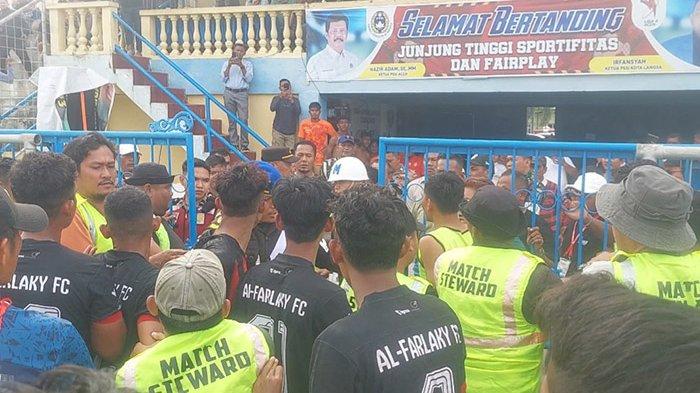 ALFARLAKY FC - Steward dan pihak keamanan saat hendak mengamankan wasit ke dalam ruang steril Stadion Langsa karena dikejar dan dikerumuni pemain Alfarlaky FC, Sabtu (15/2/2025).
SERAMBINEWS.COM/ZUBIR
