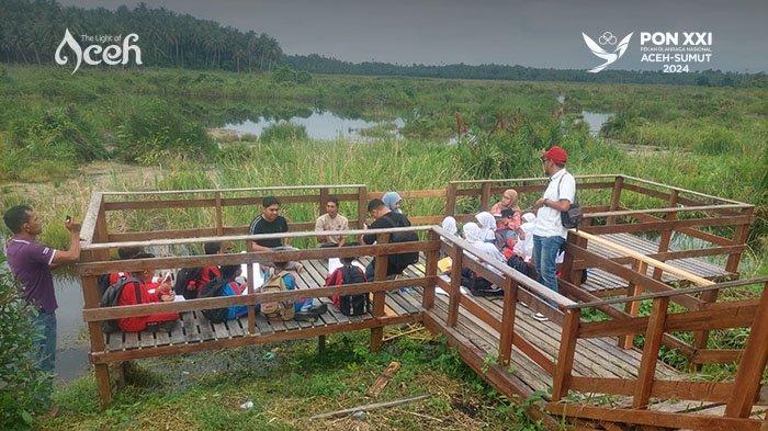 Siswa belajar tentang ekowisata Paya Nie sambil memandang luas hamparan rawa gambut tersebut.