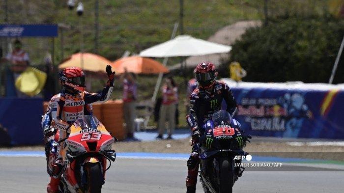 Pebalap Honda Spanyol Marc Marquez (kiri) melambai di samping pebalap Yamaha Prancis Fabio Quartararo setelah sesi kualifikasi Grand Prix MotoGP Spanyol di arena balap Jerez di Jerez de la Frontera pada 30 April 2022.