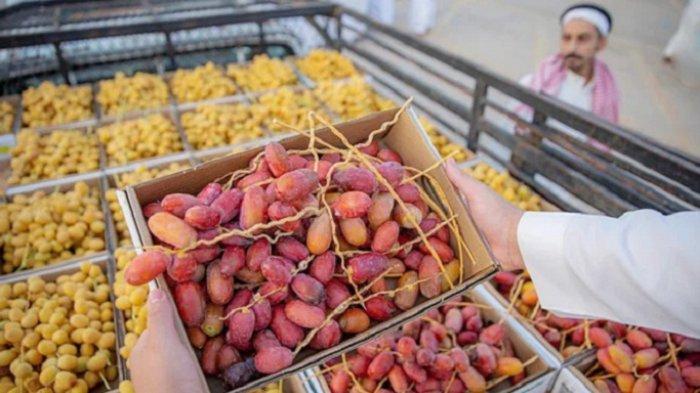Seorang pedagang memasukkan kurma ke dalam mobil pikap usai membeli dari Festival Kurma Buraidah di Provinsi Al-Qassim, Arab Saudi.