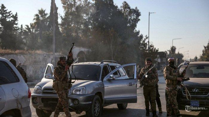Seorang pejuang antipemerintah melepaskan tembakan ke udara sementara yang lain menyaksikannya, di kota Aleppo di wilayah utara Suriah pada tanggal 30 November 2024. Para jihadis dan sekutu mereka yang didukung Turki menerobos kota kedua Suriah, Aleppo, pada tanggal 29 November, saat mereka melancarkan serangan kilat terhadap pasukan pemerintah yang didukung Iran dan Rusia.