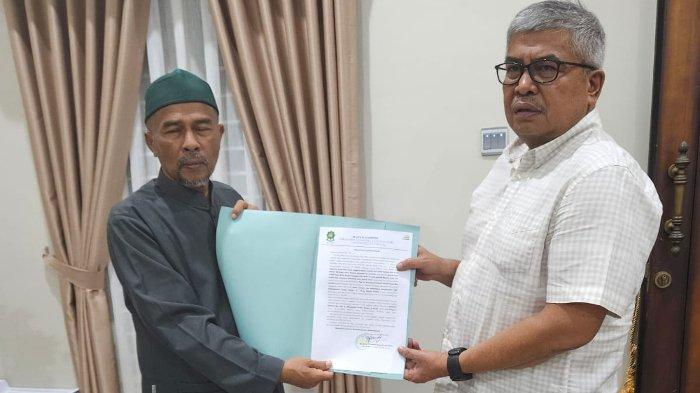 Ketua Umum PAS Aceh, Tgk Bulqaini Tanjongan menyerahkan maklumat Abu Mudi kepada calon gubernur Aceh nomor urut 1, Bustami Hamzah.