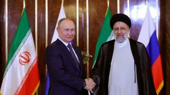 Gambar selebaran yang disediakan oleh kepresidenan Iran ini menunjukkan Presiden republik Islam Ebrahim Raisi (kanan) menyambut Presiden Rusia Vladimir Putin di Teheran pada 19 Juli 2022.