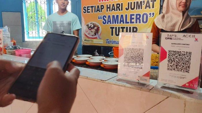 Seorang pembeli sedang melakukan scan QR code untuk melakukan pembayaran uang digital melalui QRIS di warung mie sop daging 'Salmalero Cantino', Takengon.