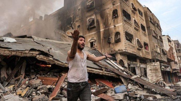 Seorang pria bereaksi di depan bangunan yang terbakar setelah dibombardir Israel di Kota Gaza pada Rabu (11/10/2023). Perang Israel vs Hamas ini pecah sejak Sabtu (7/10/2023) dan telah menewaskan ribuan orang.