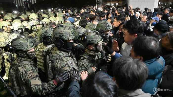 Tentara mencoba memasuki gedung Majelis Nasional di Seoul pada tanggal 4 Desember 2024, setelah Presiden Korea Selatan Yoon Suk Yeol mengumumkan darurat militer. - Presiden Korea Selatan Yoon Suk Yeol pada tanggal 3 Desember mengumumkan darurat militer, menuduh pihak oposisi sebagai