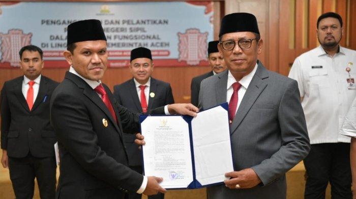 SERAHKAN SK — Wakil Gubernur Aceh, Fadhlullah, menyerahkan surat keputusan (SK) penunjukan Alhudri sebagai Plt Sekda Aceh menggantikan Muhammad Diwarsyah, di Gedung Serbaguna Kantor Gubernur Aceh, Rabu, (19/2/2025).