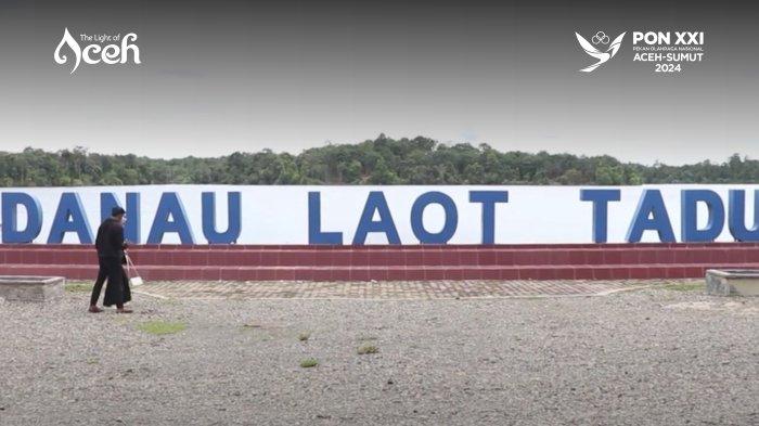 Warga berdiri di palang nama objek wisata Danau Laot Tadu di Nagan Raya