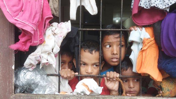 Anak-anak Rohingya, saat mengintip warga yang melakukan aksi penolakan Rohingya di eks kantor Imigrasi, Puentuet, Lhokseumawe, Kamis (8/12/2022).