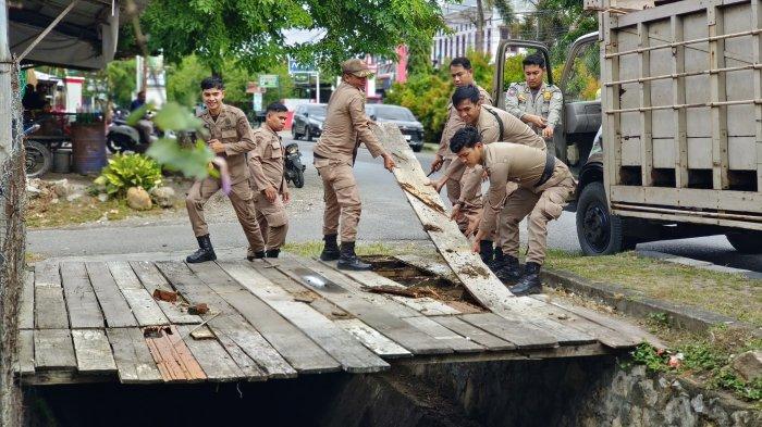 ANGKUT LAPAK - Pemerintah Kecamatan Baiturrahman bersama Satpol PP dan WH Kota Banda Aceh saat mengangkut lapak PKL liar di kawasan Jalan Teungku Sulaiman Daud, Peuniti, Rabu (2/7/2025).