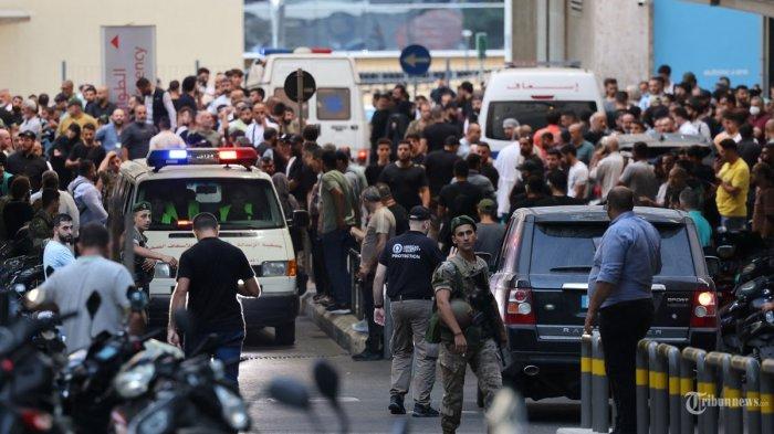 Ambulans dikelilingi oleh orang-orang di pintu masuk Pusat Medis Universitas Amerika di Beirut, pada 17 September 2024, setelah ledakan menghantam lokasi di beberapa benteng Hezbollah di sekitar Lebanon di tengah ketegangan lintas batas yang sedang berlangsung antara Israel dan pejuang Hezbollah. - Ratusan orang terluka ketika perangkat pemanggil anggota Hezbollah meledak secara serentak di seluruh Lebanon pada 17 September, dalam apa yang menurut sumber yang dekat dengan gerakan militan tersebut sebagai