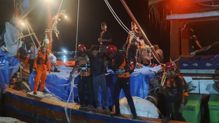 Personel Basarnas beserta 8 ABK kapal tiba di PPN Idi, pada Kamis (17/7/2025). Dua personel Basarnas sedang berusaha menurunkan salah satu ABK kapal KMP Pugo Laut 01.