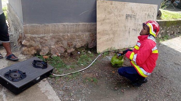 Petugas DPKP Kota Banda Aceh sedang melihat regulator gas elpiji yang bocor dan mengakibatkan dapur rumah warga Gampong Jawa, Kecamatan Kutaraja, Banda Aceh terbakar, Jumat (8/1/2021).
