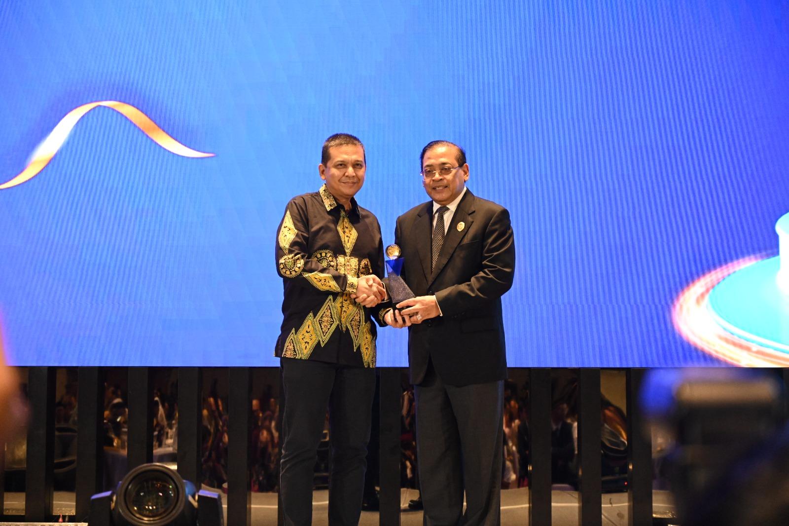 TERIMA PENGHARGAAN - Ketua Komisi Informasi Pusat Donny Yoesgiantoro menyerahkan penghargaan kepada Pemerintah Aceh, yang diterima Kepala Dinas Kominfo dan Persandian Aceh, Marwan Nusuf, di Movenpick Hotel Jakarta City Centre, Selasa (17/12/2024).