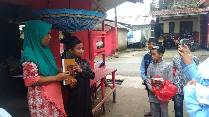 Adik-adik TPQ AL-HAFIDZ, sedang memotret penyerahan Al-Qur'an kepada warga.