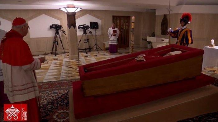 JENAZAH PAUS FRANSISKUS - Tangkapan layar YouTube Vatican News yang diambil pada Selasa (22/4/2025) menunjukkan Kardinal Camerlengo Kevin Farrell memimpin upacara penetapan kematian dan penempatan jenazah mendiang Paus Fransiskus dalam peti jenazah, yang berlangsung pada Senin malam di kapel Casa Santa Marta. Dalam gambar tersebut, Paus tampak mengenakan jubah kepausan berwarna merah dan sebuah rosario yang diletakkan di tangannya, simbol iman dan pengabdian yang ia pegang teguh sepanjang masa kepemimpinannya.