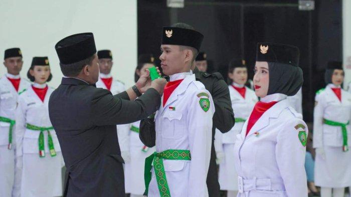 Pj Bupati Malra saat menyematkan lencana Garuda kepada salah satu perwakilan Paskibraka, Kamis (15/8/2024).