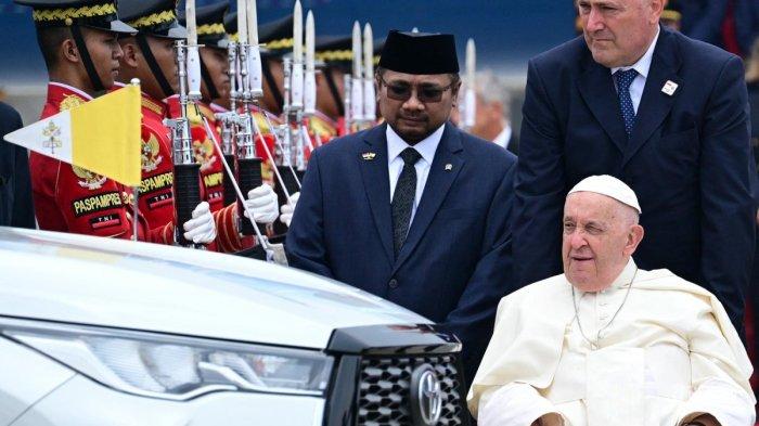 Paus Fransiskus (kanan bawah) menunggu untuk menaiki kendaraan setelah kedatangannya di Bandara Internasional Soekarno-Hatta di Jakarta pada 3 September 2024. - Paus Fransiskus tiba di Indonesia yang mayoritas penduduknya Muslim pada 3 September untuk perhentian pertama tur empat negara di Asia-Pasifik yang akan menjadi masa kepausan terlama yang dijalani Paus berusia 87 tahun. Menag komentari kesederhanaan Paus Fransiskus tiba di Indonesia tanpa kendaraaan mewah, patut dicontoh pejabat Indonesia (Tiziana FABI/AFP)
