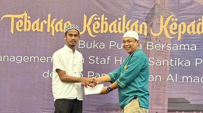 RAMADAN 2025 -- Pemberian santunan berupa uang tunai dan sembako kepada Ketua Yayasan Al Madinah dalam kegiatan buka puasa bersama Manajemen dan Staf Hotel Santika Premiere Ambon dengan Yayasan Al Madinah di The Ballroom Santika, lantai 5 Hotel Santika Premiere Ambon pada Jumat (14/3/2025).