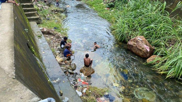 Anak-anak mandi di area bantaran sungai yang sudah tercemar sampah, Kompleks Ama Latu, Stain, Desa Batu Merah, Kota Ambon.