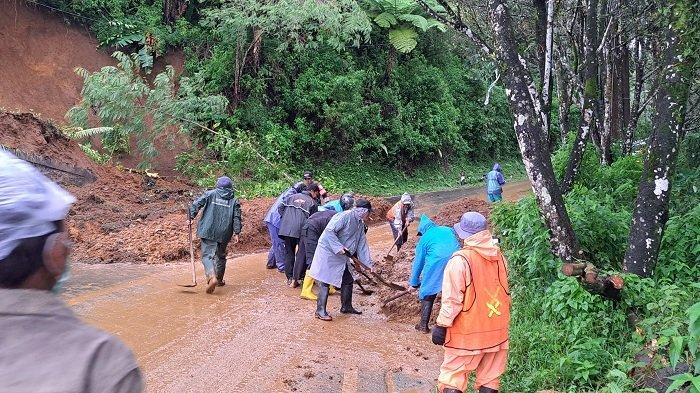 Pembersihan manual - Sejumlah relawan, warga, personel kepolisian dan kecamatan gotong royong bersihkan material longsor yang menutup badan jalan. Senin (20/1/2025)