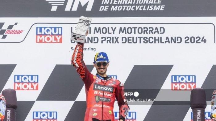 Francesco Bagnaia Merayakan kemenangannya Dengan Tropi di Podium Setelah Balapan German Motorcycle Grand Prix di Sachsenring 2024