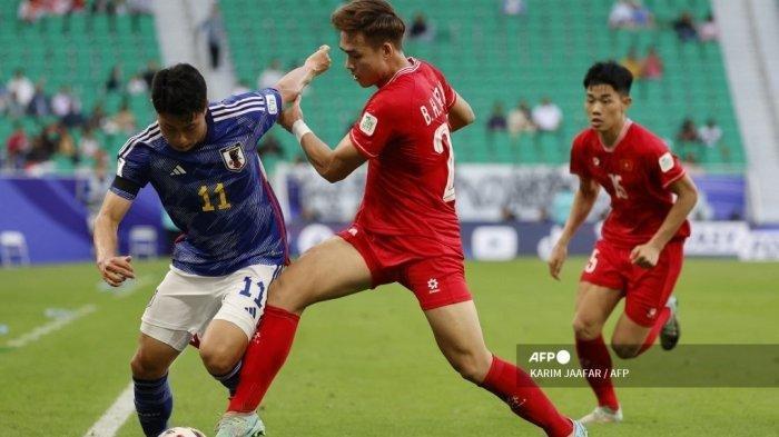 Bek Vietnam #20 Bui Hoang Viet Anh berebut bola dengan penyerang Jepang #11 Mao Hosoya selama pertandingan sepak bola Grup D Piala Asia AFC 2023 Qatar antara Jepang dan Vietnam di Stadion Al-Thumama di Doha pada 14 Januari 2024. KARIM JAAFAR / AFP