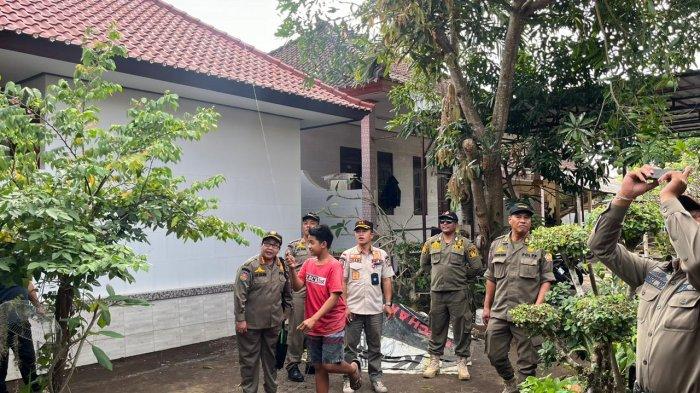 Satpol PP Badung saat menurunkan layangan di wilayah Badung selatan pada Jumat 2 Agustus 2024.