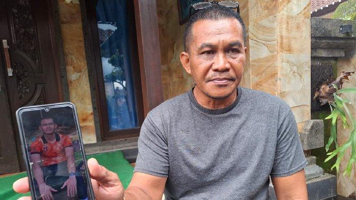Ketut Suastika saat menunjukan foto anaknya, Putu Satria Ananta Rustika (19) semasa hidup saat ditemui di kediamanya di Desa Gunaksa, Sabtu 4 Mei 2024. Keluarga merasa sangat terpukul dengan meninggalnya Putu Satria.