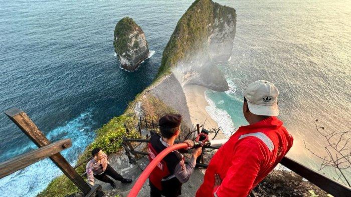 Polisi dan warga bergotong-royong padamkan kebakaran semak belukar di Pantai Kelingking, Minggu 30 Juli 2023 - Semak Belukar di Pantai Kelingking Bali Terbakar, Puluhan Wisatawan Sempat Terjebak
