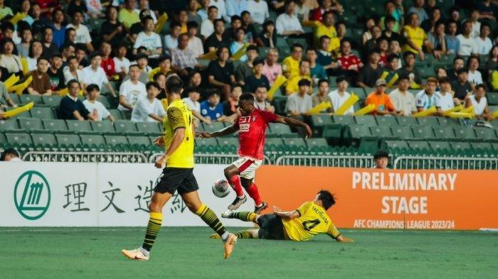 Privat Mbarga (37) ketika hendak melewati hadangan pemain bertahan Ryoya Tachibana (4) dalam pertandingan babak Kualifikasi Liga Champions Asia antara Lee Man Warriors vs Bali United di Hong Kong Stadium, Rabu (16/8/2023) malam WIB.