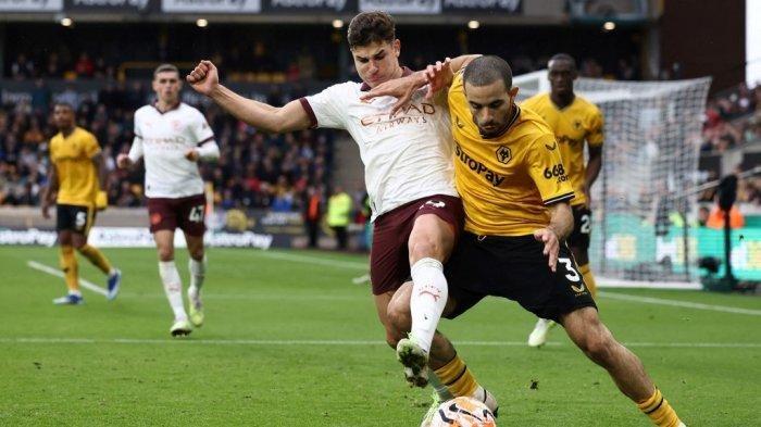 Striker Manchester City asal Argentina #19 Julian Alvarez (kiri) berebut bola dengan bek Wolverhampton Wanderers asal Prancis #03 Rayan Ait-Nouri selama pertandingan sepak bola Liga Premier Inggris antara Wolverhampton Wanderers dan Manchester City di stadion Molineux di Wolverhampton, Inggris tengah pada 30 September 2023. Darren Staples / AFP