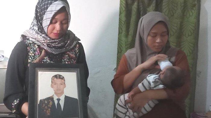 Keluarga Praka Dwi Bekti Probo Siniwoko, menunjukkan foto almarhum, saat di rumah duka, Desa Tegalarum, Kecamatan Bendo, Magetan, Senin (27/11/2023). Praka Dwi merupakan satu dari tiga prajurit yang gugur saat terjadi insiden baku tembak, dengan KKB Papua, Sabtu (25/11/2023).
