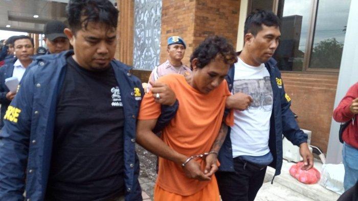 TERSANGKA - Tersangka Ahmad Santoso (32) dalam kasus viral penemuan mayat Suparno di Jalan Pura Demak Barat 18 di sebuah lahan kosong yang berisi pohon pisang dan semak-semak di Desa Pemecutan Kelod, Denpasar Barat, Denpasar, bali, pada Sabtu 22 Februari 2025.