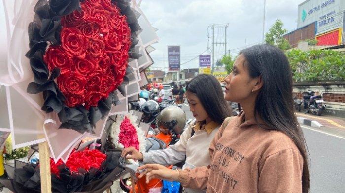 BELI BUNGA – Pembeli berbondong-bondong membeli bunga tepatnya di Jalan Sutoyo Denpasar, Jumat (14/2). Pendapatan florist di Denpasar meningkat saat perayaan hari Valentine.