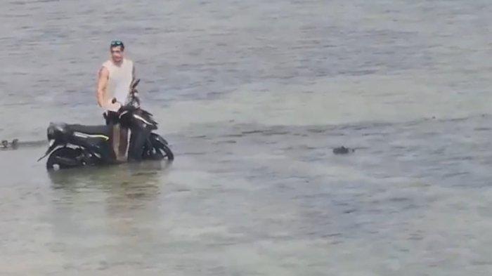 MENYEBERANG – Seorang WNA menaiki sepeda motor hendak menyeberang dengan melintasi lautan antara Pulau Ceningan dan Pulau Lembongan, Selasa (27/8).