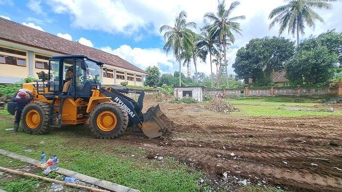 JELANG PELANTIKAN - Perataan lahan belakang gedung DPRD Bangli untuk persiapan pelantikan anggota dewan terpilih, Senin (29/4).