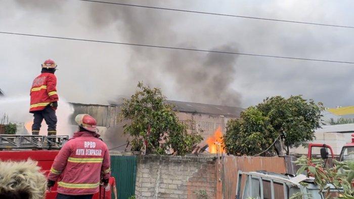 Proses pemadaman api yang membakar sebuah gudang gas Elpiji di Jl. Cargo Taman I, Denpasar. Tampak petugas memadamkan api dari luar gudang.