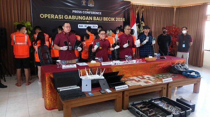 BARANG BUKTI - Ketua Tim Pengawasan Satgas Bali Becik Arief Eka (paling kiri), Dirwasdakim Saffar Muhammad Godam (kedua dari kiri) menunjukkan barang bukti dari 103 WNA yang diduga melakukan kejahatan siber, saat jumpa pers di Rumah Detensi Imigrasi (Rudenim) Denpasar, Jumat (28/6).