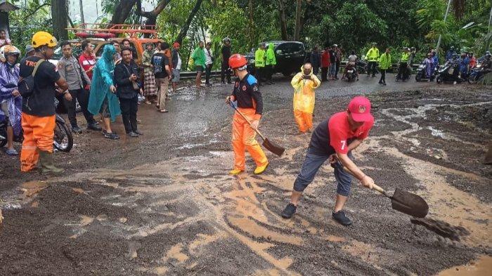 BENCANA - Petugas saat membersihkan material longsor dan banjir di jalan penghubung Karangasem-Klungkung, tepatnya di Desa Bugbug, Karangasem, beberapa waktu lalu. Kerugian akibat longsor dan banjir di Karangasem diperkirakan mencapai Rp 531 juta.