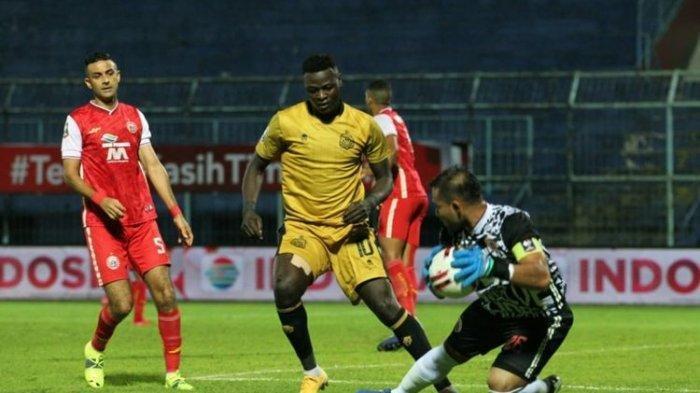 Penyerang Bhayangkara FC, Ezechiel Ndouassel, berduel dengan kiper Persija, Andritany Ardhiyasa, pada laga Persija Jakarta vs Bhayangkara Solo FC di Grup B Piala Menpora 2021 di Stadion Kanjuruhan, Malang, Jawa Timur pada Rabu (31/3/2021) sore hari WIB.